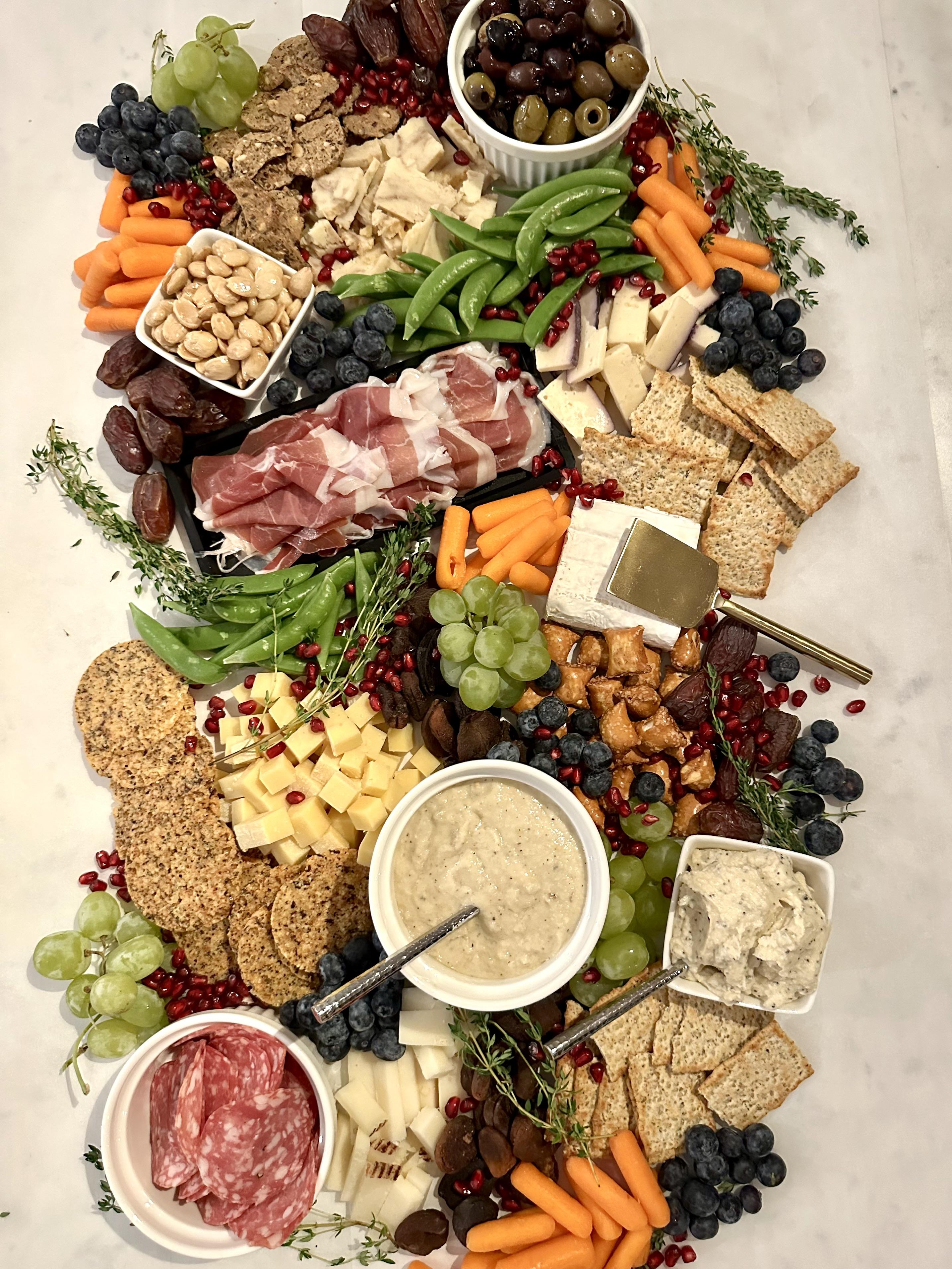Abundantly styled grazing board with cured meats, cheeses, and fresh garnishes