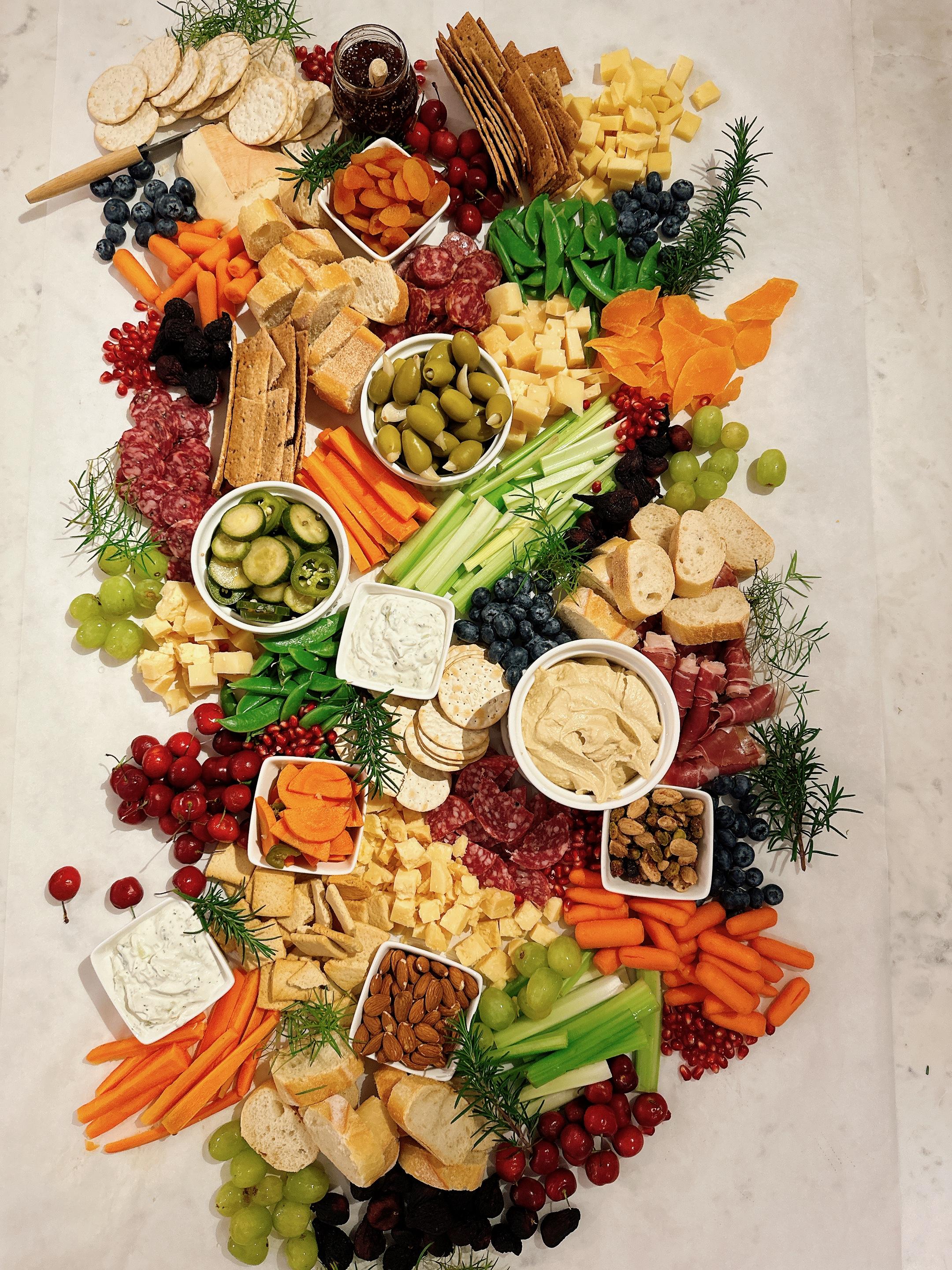 Lush charcuterie board with figs, brie, prosciutto, and fresh herbs